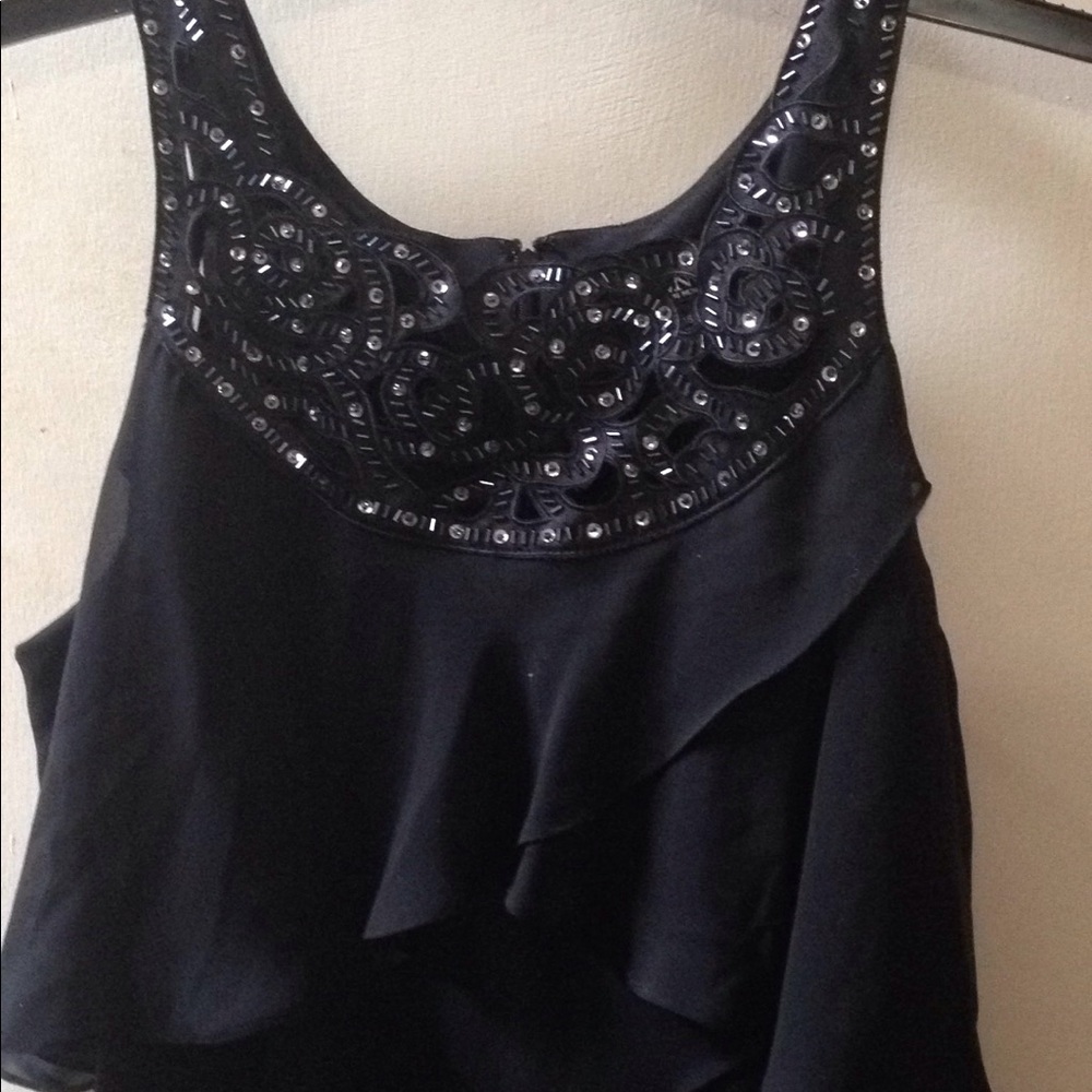 A sleeveless black ruffles dress with beads